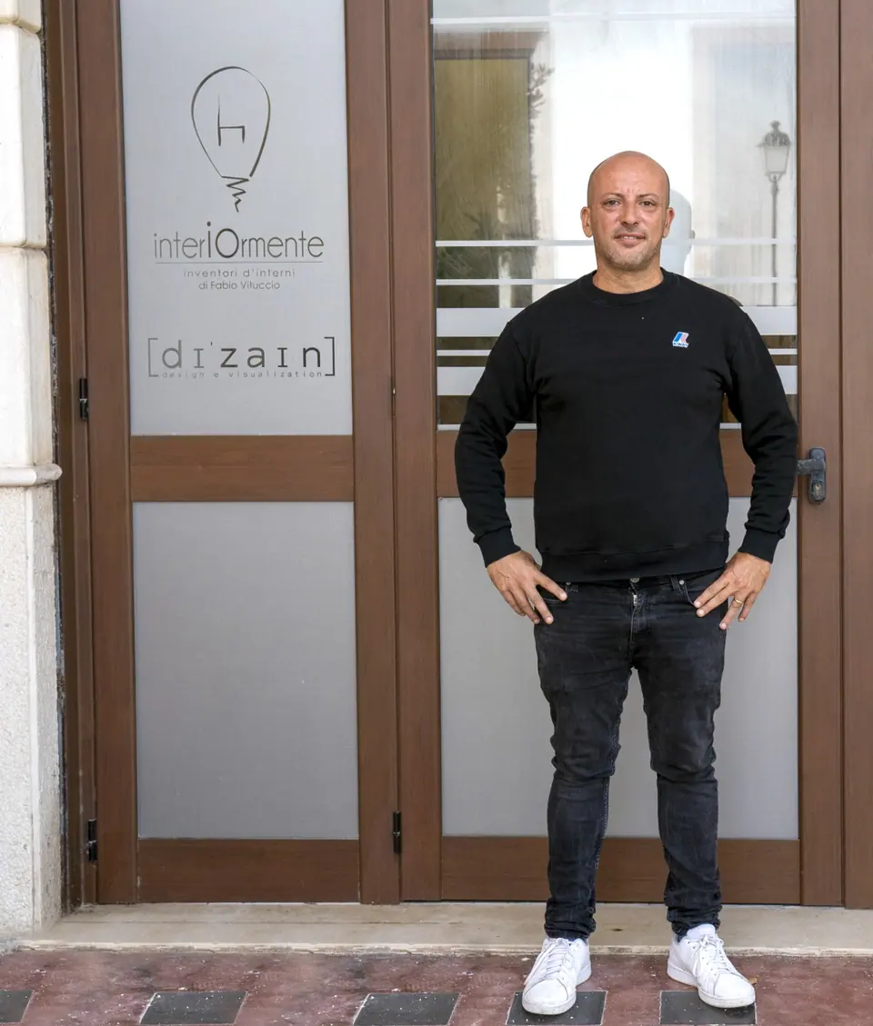 Fabio Vituccio in piedi davanti alla porta a vetri dello studio Interiormente a Trani